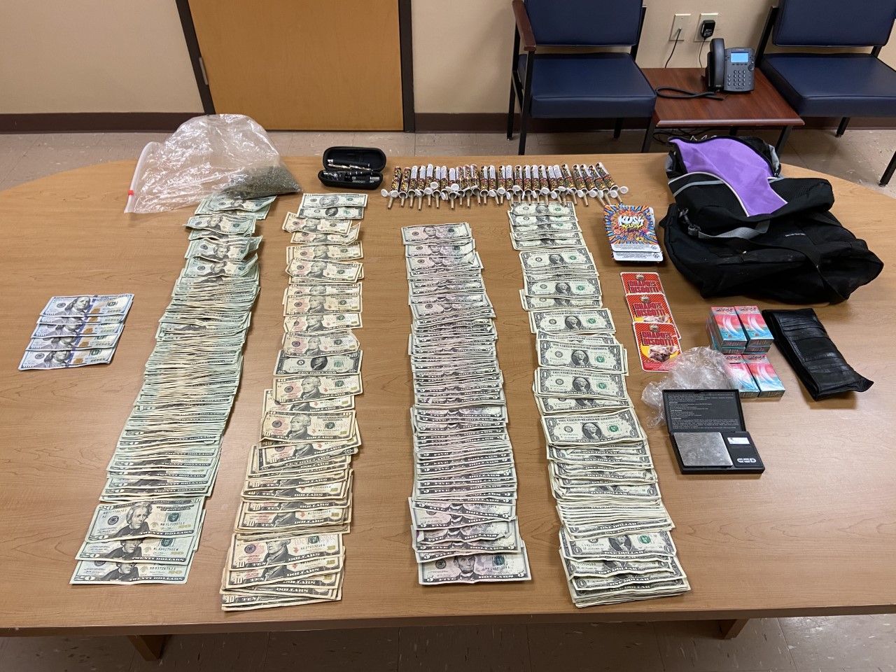 large amount of cash and drugs fanned out on a wooden table top