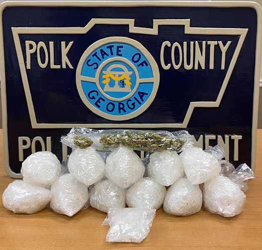 bags of drugs on a table with a polk county police logo in the background