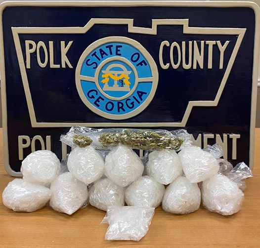 bags of drugs on a table with a polk county police logo in the background
