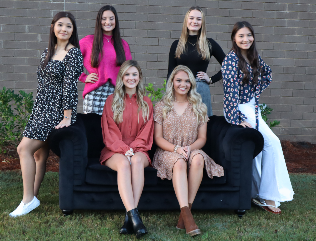 six teens sitting and standing around a couch